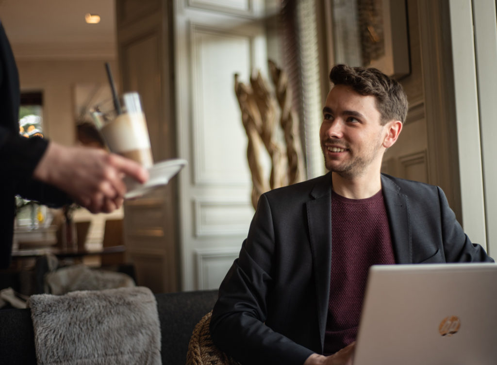 Homme prenant une boisson au salon